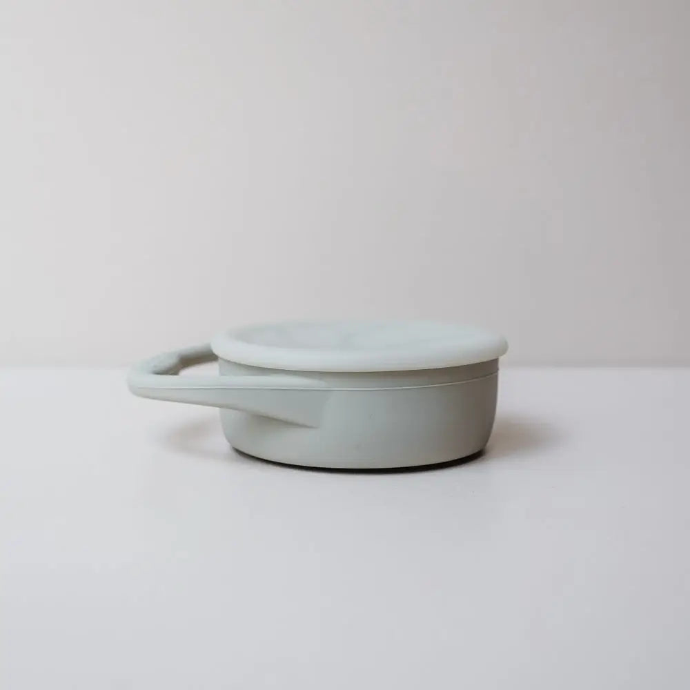 Collapsible snack cup in grey on a flat surface